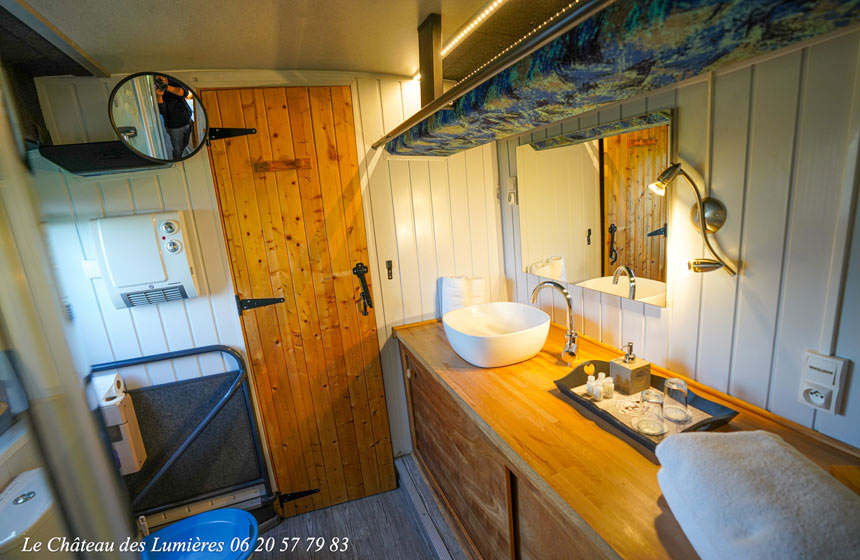Salle de douche avec toilettes dans le bus du Château des Lumières